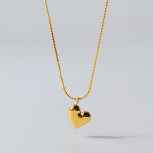 Detailed view of a 3D heart pendant necklace with a high-polished gold finish on rope chain