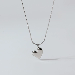 Polished silver heart pendant on a thin chain shown against a clean white background