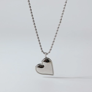 Detail of silver heart pendant with double-layered edges on a delicate rope chain