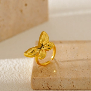 Detail eines goldenen 3D-Schmetterlingsrings auf Stein mit verstellbarem Design im Fokus