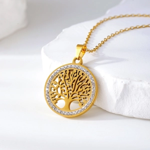 Elegante gouden levensboom ketting met witte zirkonia op een witte stenen ondergrond