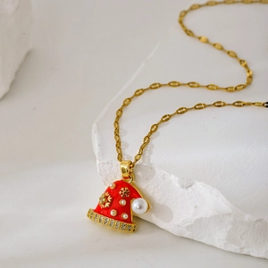 Detail eines Weihnachtsmützen-Anhängers mit rotem Emaille, Perlen und Gold-Schneeflocken