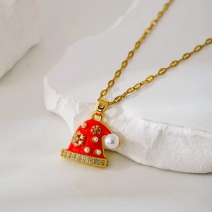 Nahaufnahme einer goldenen Weihnachtsmützen-Halskette mit Emaille und Perle
