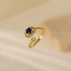 Anello dorato regolabile con gemma blu scuro circondata da zirconi bianchi lucidi