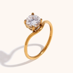 Detail van de golfvormige 18K gouden ring met een fonkelende zirkonia in vierpootzetting