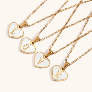Detail van vier 18K vergulde hart-schelp hangende kettingen met L-O-V-E letter hangers