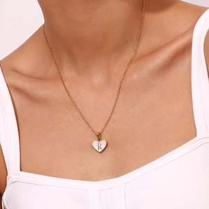Detail van de 18K vergulde hartjesketting met schelpinlegsel en gegraveerde letter R