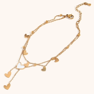 Detail of double-layered gold heart anklet with white shell inlay and adjustable clasp