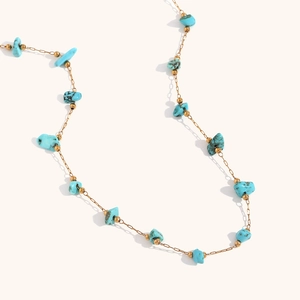 Détail macro de la chaîne plaquée or 18K avec pierres de turquoise et perles dorées