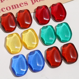 Close-up of diamond-shaped resin charms with glitter finish for DIY jewelry making