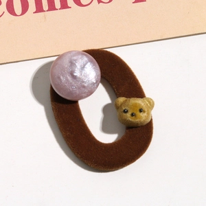 Cute brown flocked bear and lavender bead hair tie on a decorative pink card