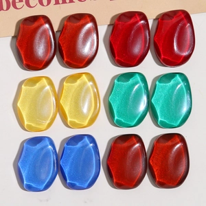 Macro detail of pebble-shaped resin charms with cat-eye effect for DIY earring crafts