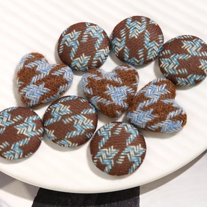 Detailed view of houndstooth tweed fabric buttons in heart and round shapes