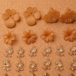 Vue détaillée de breloques fleurs et feuilles en acrylique ambré pour bijoux DIY