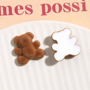 Macro shot of brown flocked bear charm with white flat back for DIY crafts and accessories