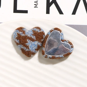 Detail of houndstooth wool fabric heart buttons with metal base for DIY sewing