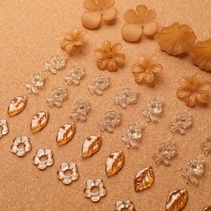 Gros plan de breloques fleurs et feuilles en acrylique ambré pour bijoux DIY
