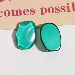 Macro view of dark green resin geometric earring charms with silk luster finish