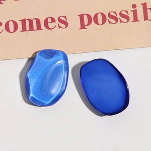 Macro shot of irregular oval resin charms in bright lake blue and deep sapphire blue tones