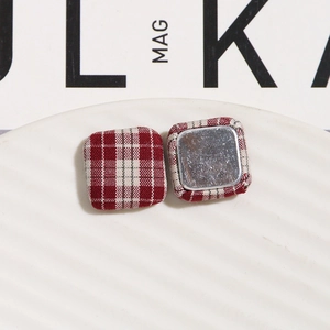 Detailed macro of red checkered fabric square button showing metallic magnetic backing