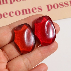 Close-up of vibrant red cat-eye resin cabochons for DIY earring and hair jewelry making