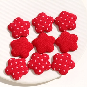 Detailed view of red fabric star charms with polka dots for DIY hair accessories and jewelry