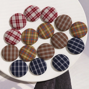 Macro shot of assorted round fabric-covered buttons with classic plaid and check patterns
