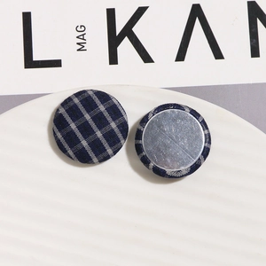 Detail of dark blue plaid fabric buttons with flat silver metal base for DIY hair clips