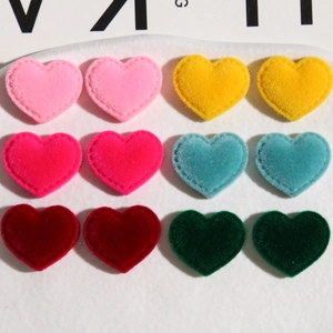 Macro detail of heart-shaped flocked patches in various colors for DIY craft accessories