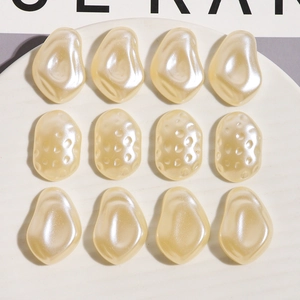 Close-up of 12pcs irregular pearl-like resin charms with textured surfaces for DIY