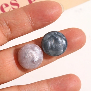 Nahaufnahme glitzernder Harz-Cabochons in Lila und Grau für DIY-Schmuckherstellung