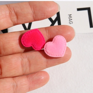 Detail view of heart-shaped flocked patches in rose and light pink for DIY crafts