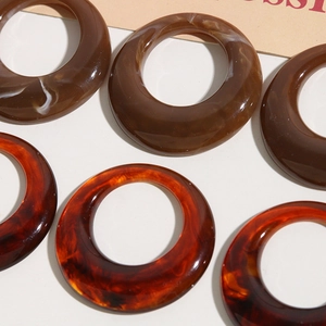 Primer plano de anillos redondos de resina jaspeada para pendientes y bisutería