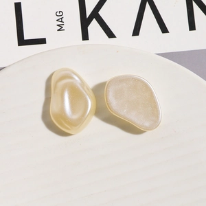 Macro shot of cream white irregular faux pearl earrings with a pearlescent finish