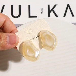 Irregular pebble-shaped cream acrylic stud earrings on a display card for DIY jewelry