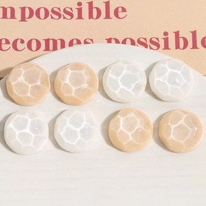 Macro view of textured resin shoe buckle accessories with honeycomb pattern in beige and white