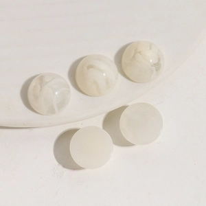 Dettaglio di cinque cabochoni in resina marmorizzata da 16mm per gioielli fai-da-te e clip