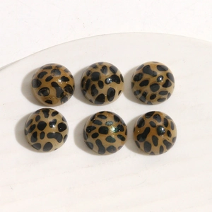 Flat lay of circular leopard print acrylic charms with glossy finish for DIY jewelry
