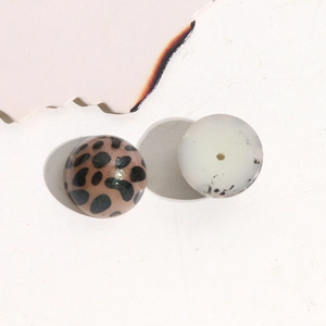 Macro shot of leopard print acrylic beads and milky translucent round resin components