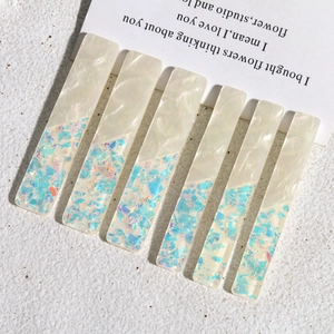Détail de barrettes rectangulaires en acrylique avec texture nacrée et paillettes colorées