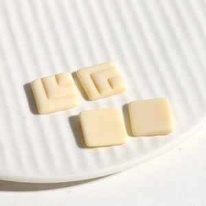 Macro detail of creamy white geometric resin square charms for DIY earring and jewelry crafts
