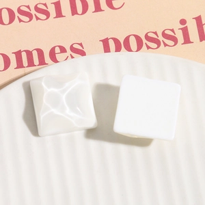 Dettaglio dell'accessorio quadrato in resina bianca con una texture a onde d'acqua