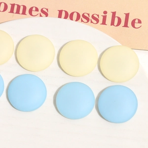 Macro shot of 26mm matte resin round flatback beads in pastel yellow and sky blue
