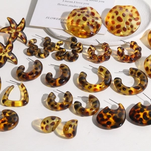 Detailed close-up of leopard print acrylic earrings in starfish and C-shape styles