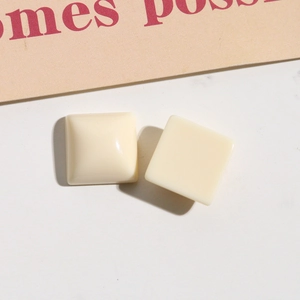 Dettaglio di ciondoli quadrati in resina bianco crema per orecchini e decorazioni