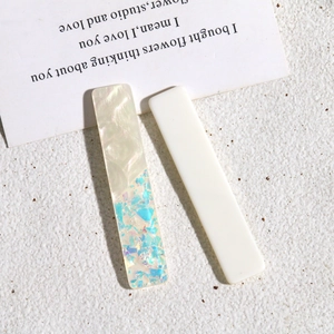 Détail de barrettes rectangulaires en résine avec textures nacrées et paillettes