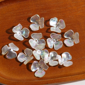 Macro detail of iridescent clover flower charms with pearlescent finish for DIY jewelry