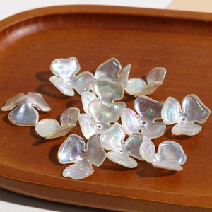 Macro shot of iridescent acrylic three-leaf flower beads for DIY jewelry making accessories