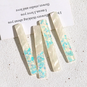 Vue détaillée de barrettes en acrylique aux textures perle blanche et laser bleu