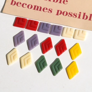 Macro view of geometric resin charms with textured V-shape patterns for DIY jewelry making